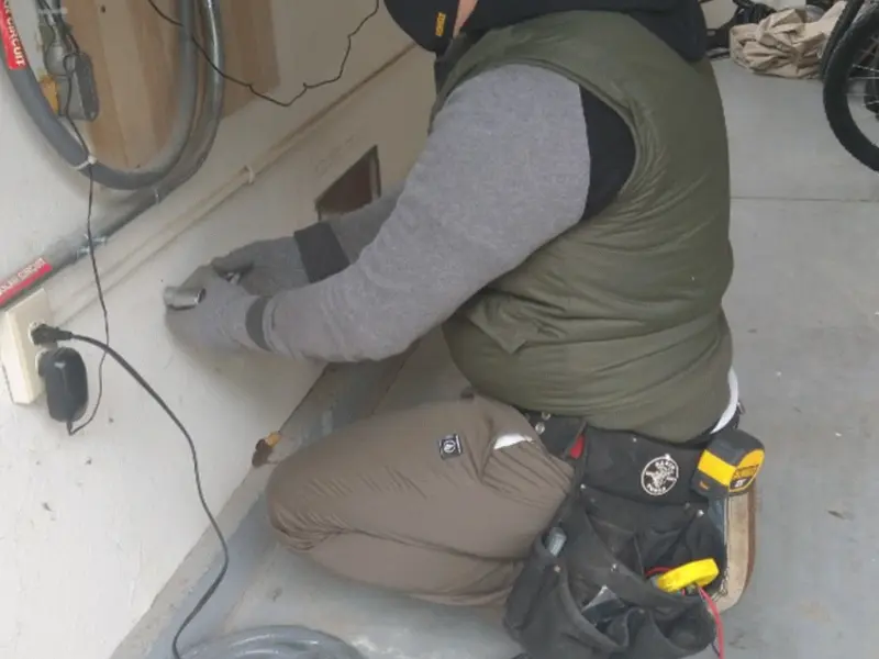 Electrician performing outlet wiring in a Bright garage